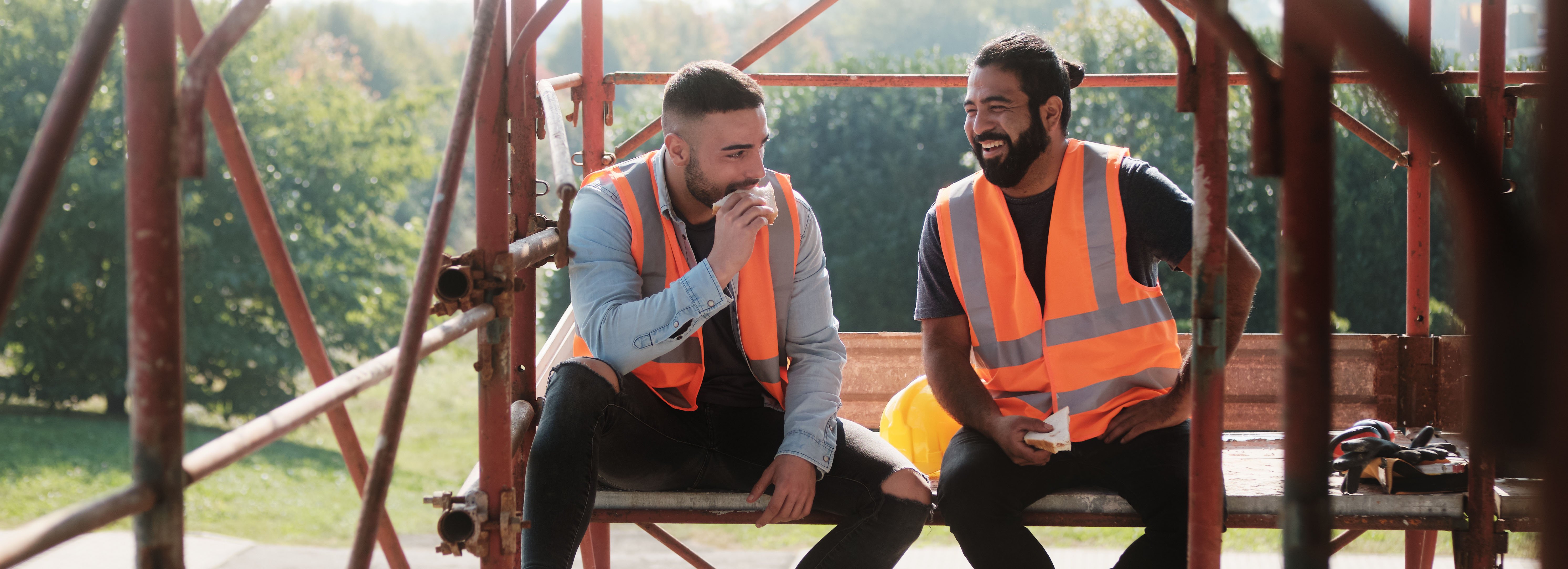 Happy Workers In Construction Site During Lunch Break