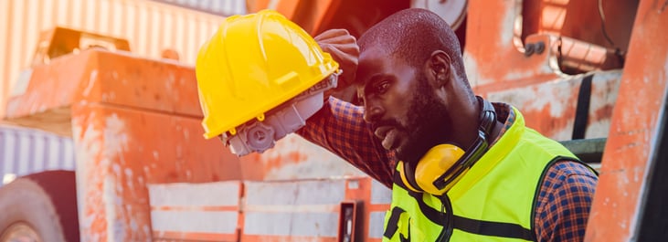 Tired, stressed worker sweating from hot weather in summer working in port goods cargo shipping logistic ground